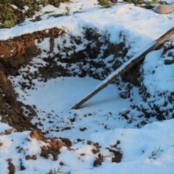 Grube mit Aussteigshilfe für Tiere, von Schnee überzogen.